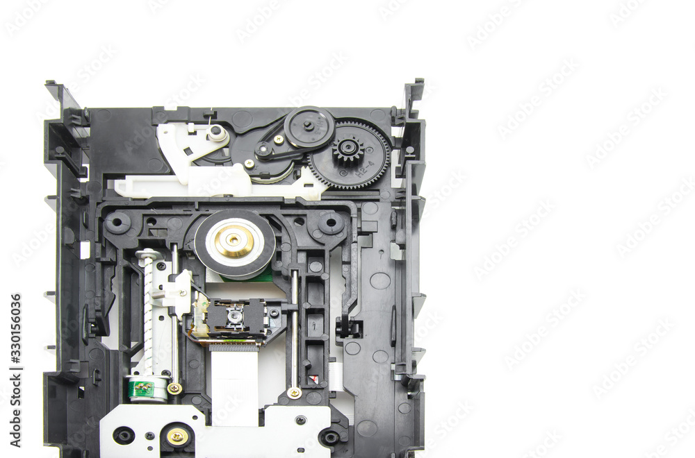 Disassembled optical CD-ROM drive in black. Opened CD reader. Drive, laser, motor, gears and other mechanisms. White isolated background. Disassembled optical CD-ROM drive in black. Opened CD reader. Drive, laser, motor, gears and other mechanisms. White isolated background.