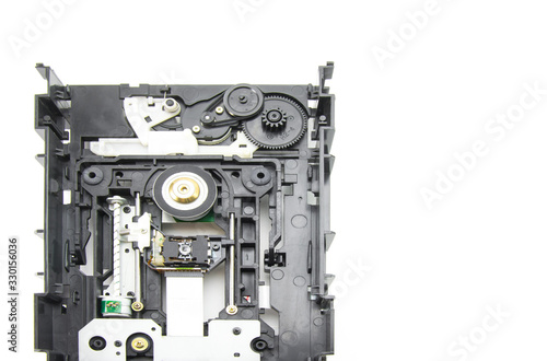 Disassembled optical CD-ROM drive in black. Opened CD reader. Drive, laser, motor, gears and other mechanisms. White isolated background.