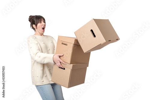 Clumsy woman carrying stack of falling cardboard boxes