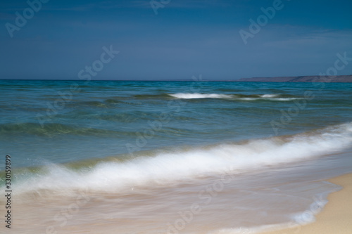 View of blue sea waves at sandy beach. Horizon line. Caspian Sea, sandstone coast. ustyurt. Selective focus, long shutter speed
