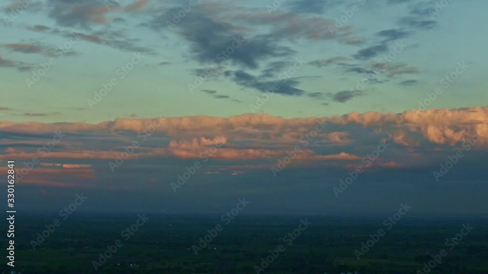 slow panorama left at tropical landscape with fluffy pink clouds at blue sky at sunset slow panorama left at tropical landscape with fluffy pink clouds at blue sky at sunset