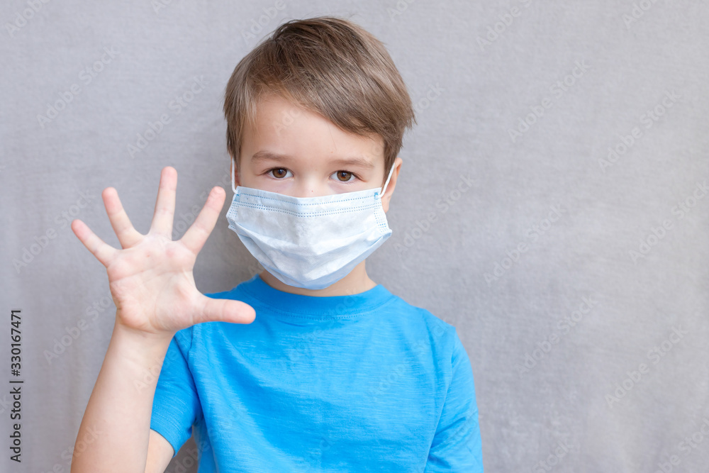 Portrait of Toddler kid wearing medical mask.A boy wearing mouth mask against air smog pollution. Concept of coronavirus quarantine or covid-19.Protection against virus and infection control concept. 