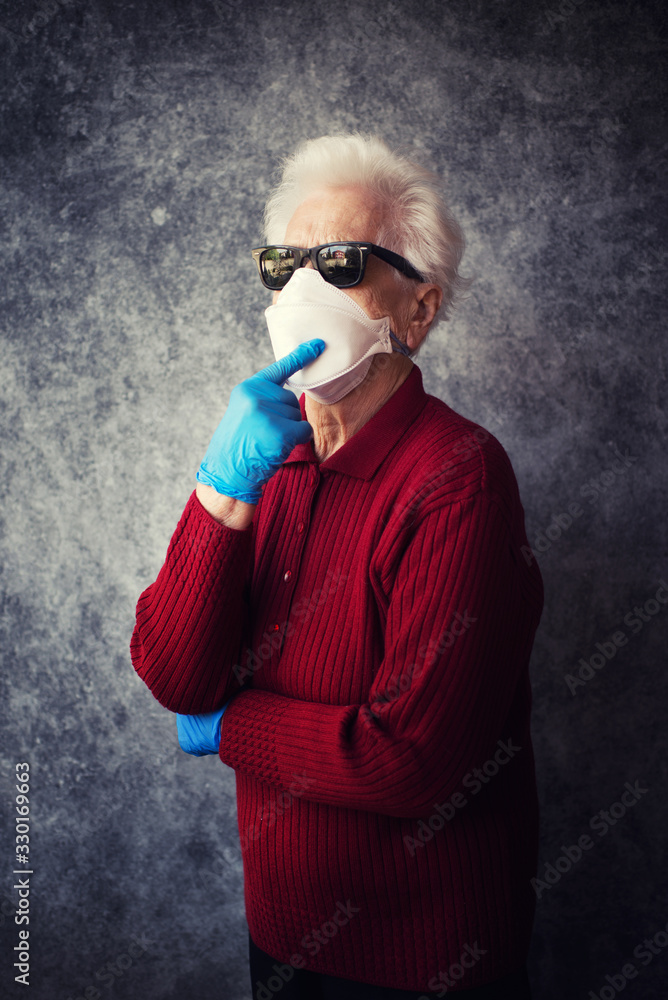Old grandmother protect herself from coronavirus infection with medical gloves and respirator mask Old grandmother protect herself from coronavirus infection with medical gloves and respirator mask