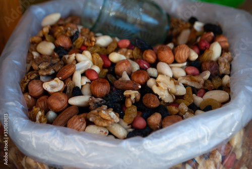 Close-up of different kinds of nuts in a plastic transparent bag on the local bazaar. Walnuts, hazelnuts, almonds, peanuts and raisins. Preparation for Novruz holiday. Nuts for khoncha photo