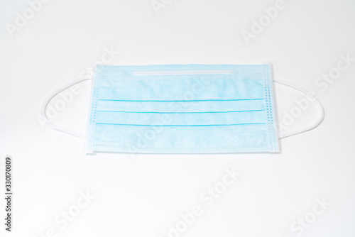 Surgical mask with rubber ear straps. Typical 3-ply surgical mask to cover the mouth and nose. Procedure mask from bacteria. Protection concept.