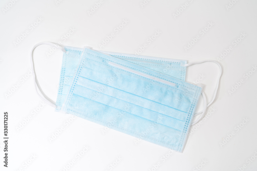 Surgical mask with rubber ear straps. Typical 3-ply surgical mask to cover the mouth and nose. Procedure mask from bacteria. Protection concept. Surgical mask with rubber ear straps. Typical 3-ply surgical mask to cover the mouth and nose. Procedure mask from bacteria. Protection concept.