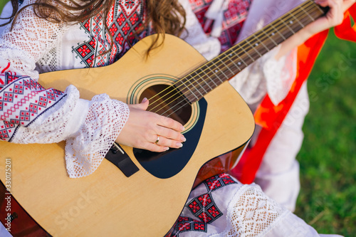 closeup of guitar and girl hands with wedding ring on ring finge photo