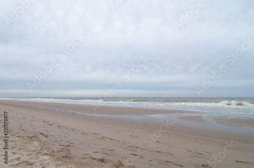 Strand im Regen mit grauen Wolken