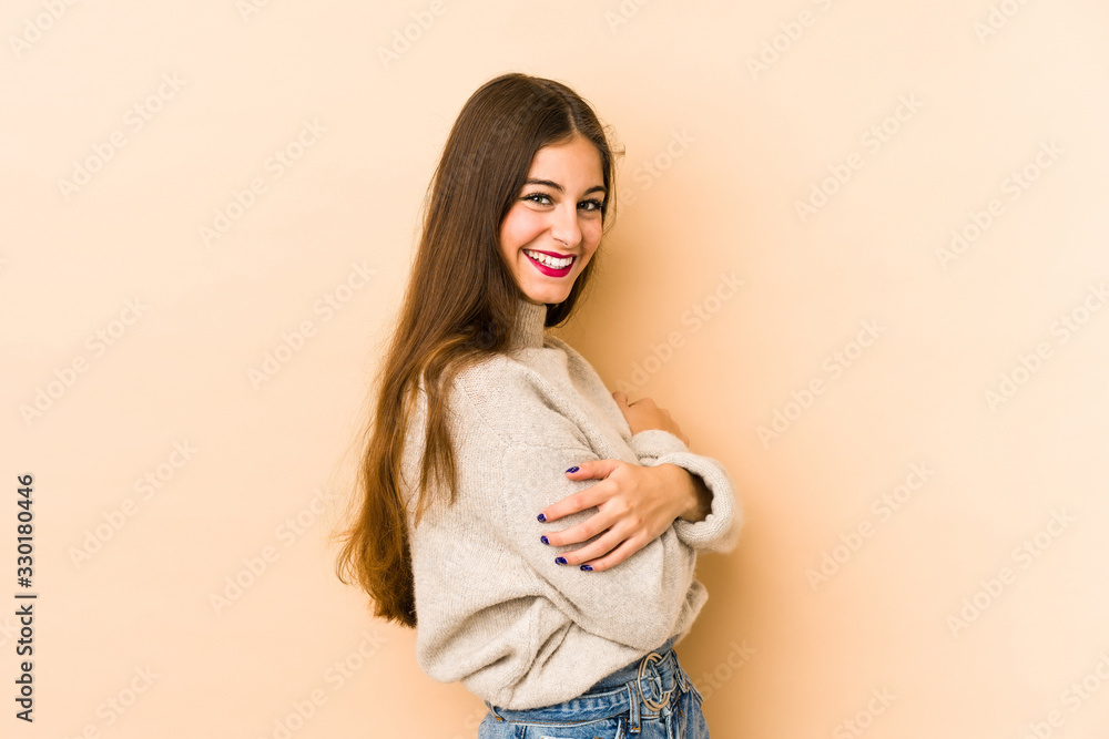 Young caucasian woman isolated en beige background laughing and having fun. Young caucasian woman isolated en beige background laughing and having fun.