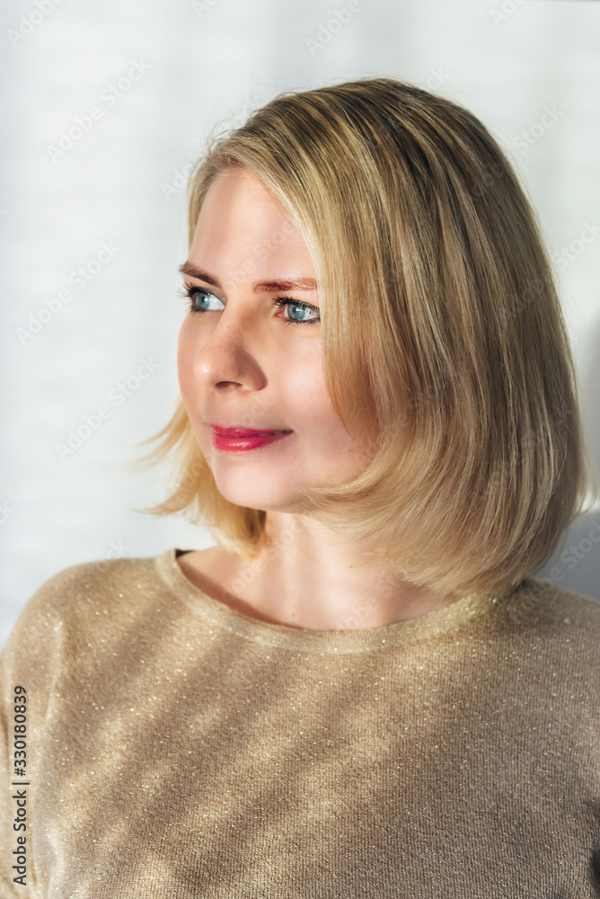portrait of a beautiful girl looks to the left. a close-up shot of a serious young blonde woman in light clothing portrait of a beautiful girl looks to the left. a close-up shot of a serious young blonde woman in light clothing