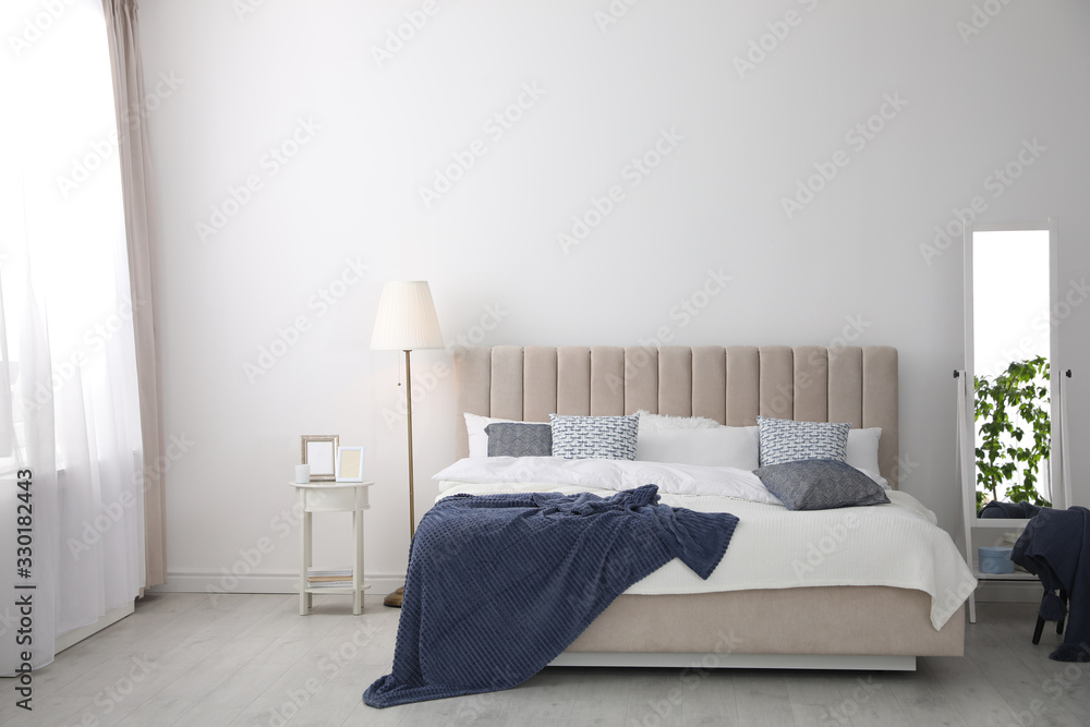 Comfortable bed with pillows in room. Stylish interior design - obrazy, fototapety, plakaty 