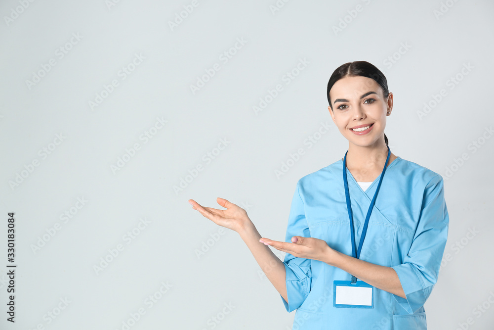 Portrait of young doctor against light background