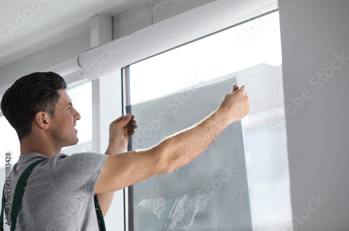 Professional worker tinting window with foil indoors © New Africa