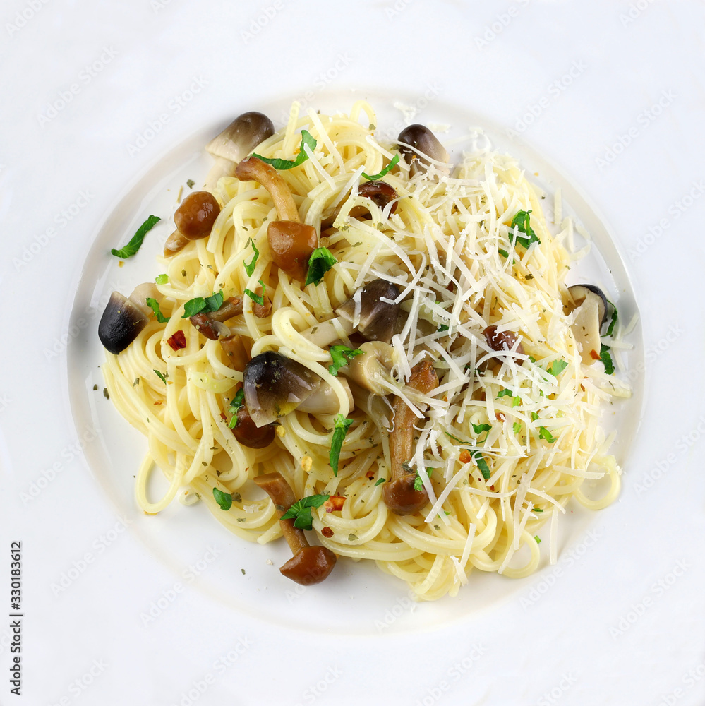Concetto di cucina italiana. Vista superiore della pasta fatta in casa degli spaghetti con i funghi isolati su fondo bianco.