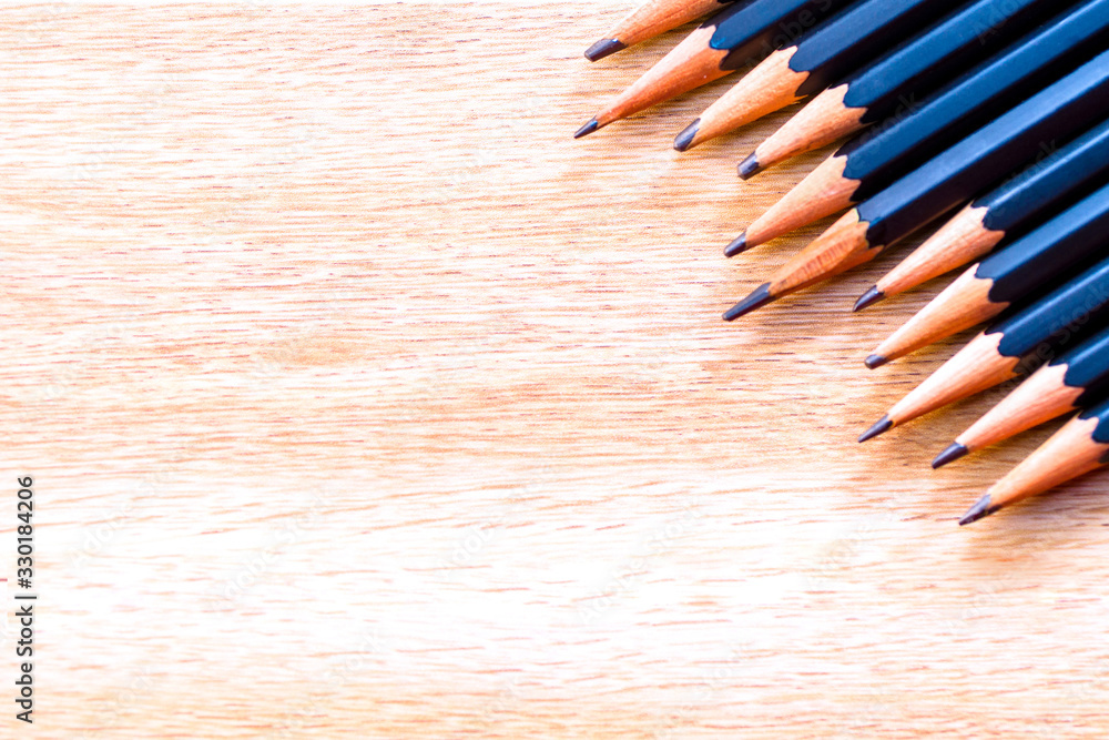 Obraz premium black pencils isolated on wood surface background.Close up.