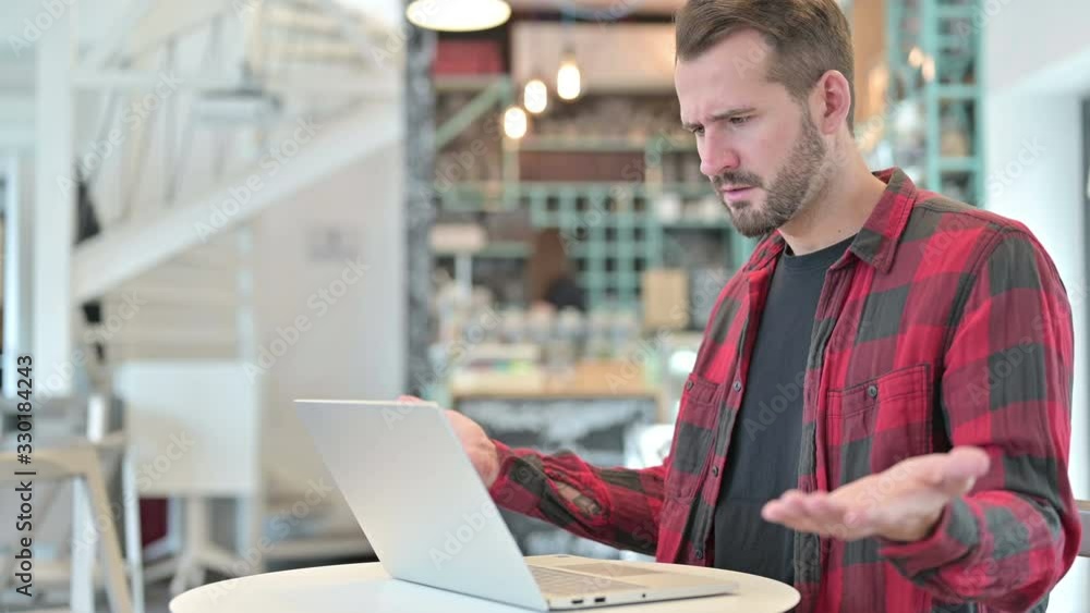 Surprised Young Man Reacting to Loss on Laptop in Cafe Surprised Young Man Reacting to Loss on Laptop in Cafe