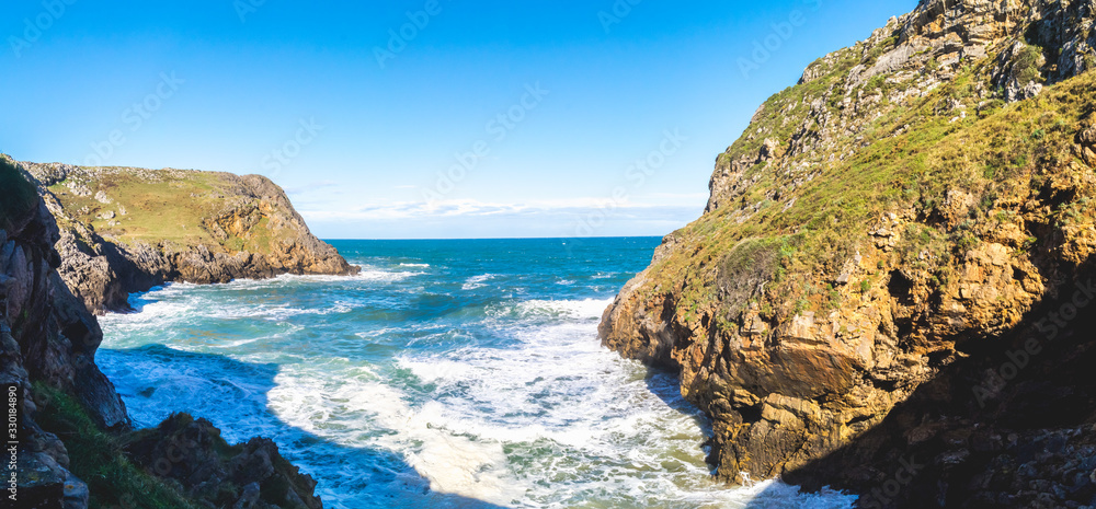 Panoramic view of the cliffs of La Mina cove in sunny day, Prell