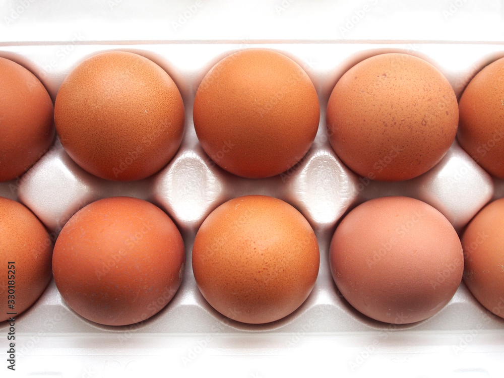Ten chicken eggs in a plastic box , healthy organic product, brown eggs on a white background. Useful natural product for a healthy diet. Ten chicken eggs in a plastic box , healthy organic product, brown eggs on a white background. Useful natural product for a healthy diet.
