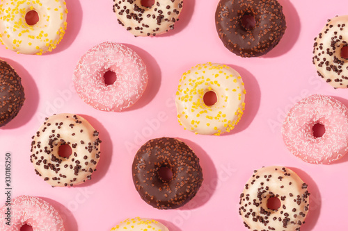 Tasty donuts pattern on pink background. Sweets and desert concept. Flat lay, top view. 