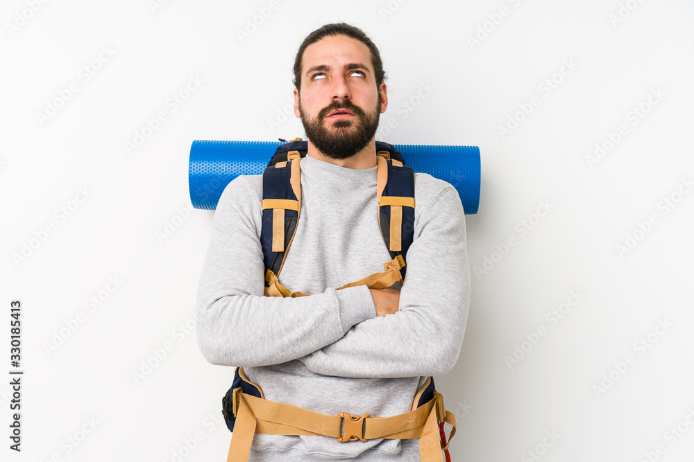 Young backpacker man isolated on a white background tired of a repetitive task. Young backpacker man isolated on a white background tired of a repetitive task.