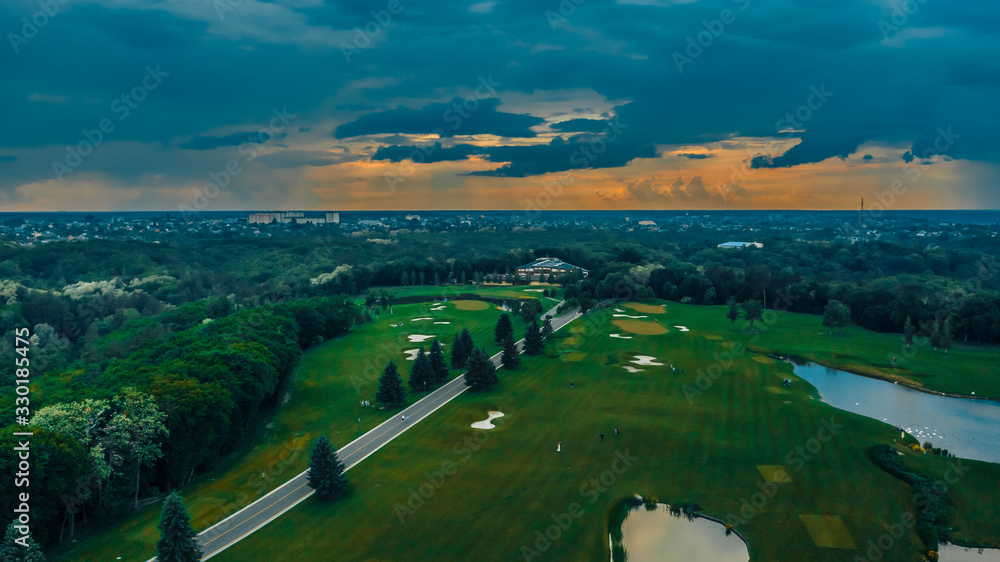 spectacular and very colorful sunset over the golf course in the private residence of Mezhyhiria and the small village of New Petrovtsy .Kyiv, Ukraine - Cityscape Aerial Flight