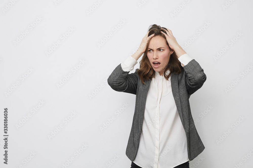 Businesswoman pulling her hair in frustration Businesswoman pulling her hair in frustration