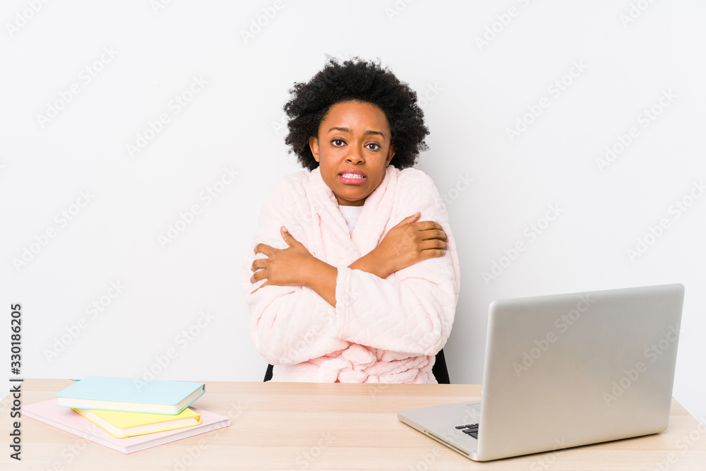 Middle aged african american woman working at home isolated going cold due to low temperature or a sickness. Middle aged african american woman working at home isolated going cold due to low temperature or a sickness.
