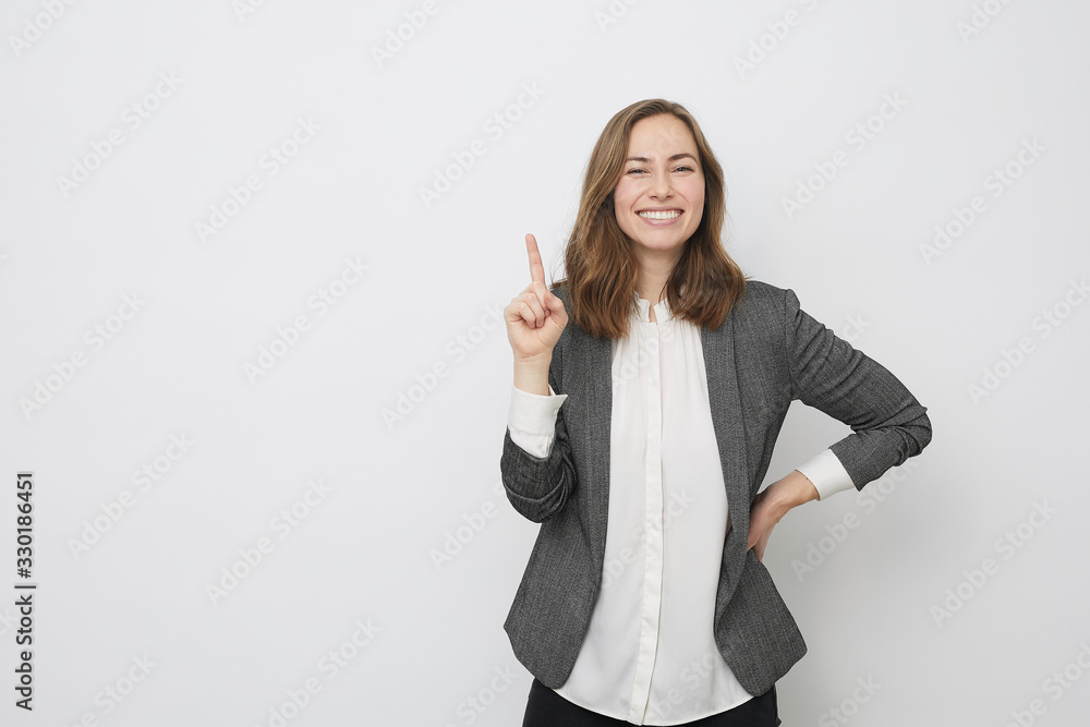Businesswoman is pointing up while looking Businesswoman is pointing up while looking
