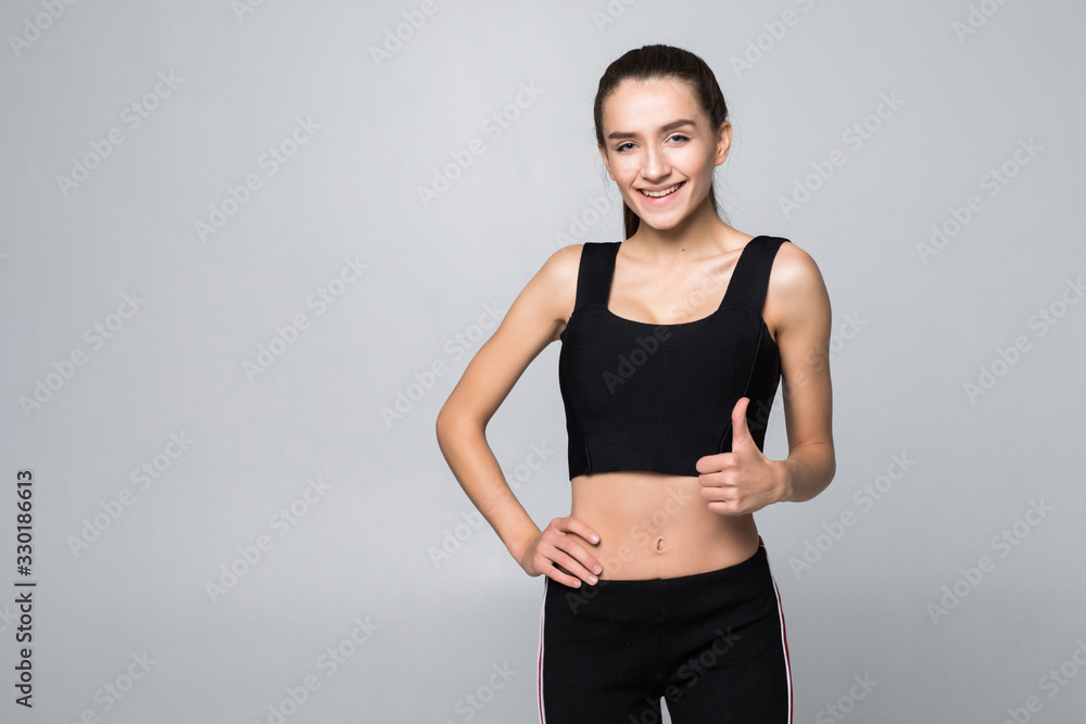 Happy fitness woman showing thumb up isolated on a white background Happy fitness woman showing thumb up isolated on a white background