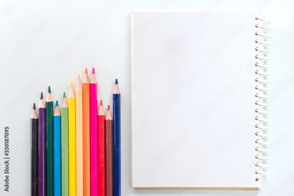 notepad with color pencil on white table view from above notepad with color pencil on white table view from above