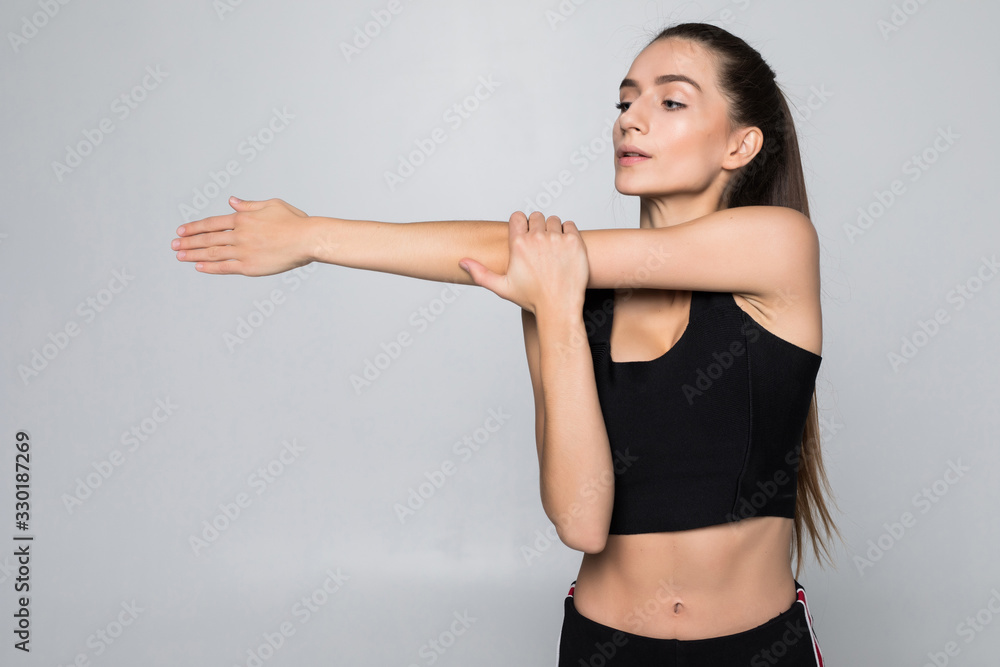 Portrait of a smiling fitness woman stretching her hands over white background Portrait of a smiling fitness woman stretching her hands over white background
