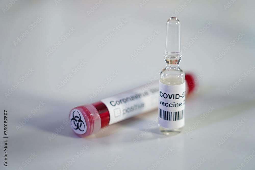 Close up of positive Coronavirus blood test with biohazard label and ampoule with COVID-2019 antidote vaccine. Close up of positive Coronavirus blood test with biohazard label and ampoule with COVID-2019 antidote vaccine.