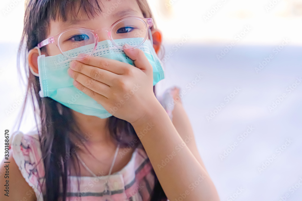 Portrait Asian kid wearing medical mask. A girl wearing mouth mask against air smog pollution. Concept of corona virus quarantine or covid-19.Protection against virus and infection control concept. Portrait Asian kid wearing medical mask. A girl wearing mouth mask against air smog pollution. Concept of corona virus quarantine or covid-19.Protection against virus and infection control concept.
