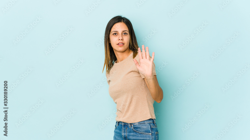 Young woman isolated on blue background being shocked due to an imminent danger Young woman isolated on blue background being shocked due to an imminent danger