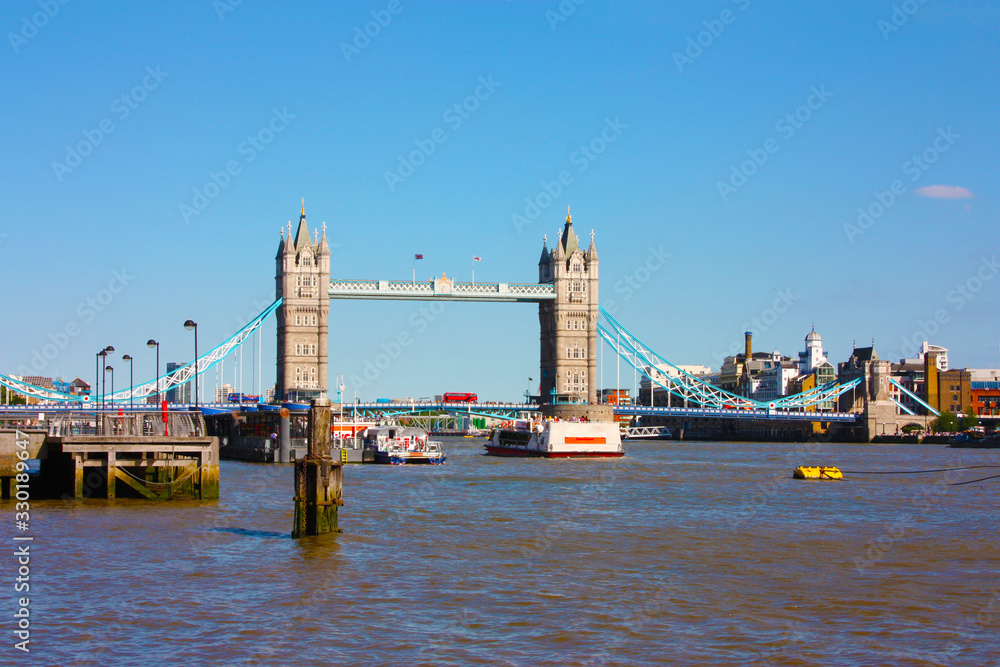 London Bridge over the River Thames with boats in the blue sky