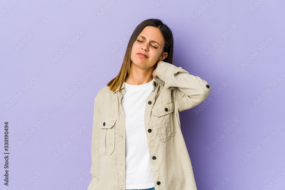 Young woman isolated on purple background suffering neck pain due to sedentary lifestyle. Young woman isolated on purple background suffering neck pain due to sedentary lifestyle.