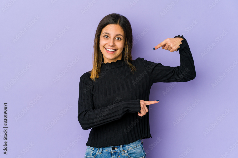 Young woman isolated on purple background holding something little with forefingers, smiling and confident. Young woman isolated on purple background holding something little with forefingers, smiling and confident.