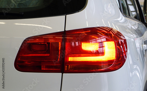 Red rear taillight of a modern car close-up. Service, repair, body repair, body painting, spare parts concept.