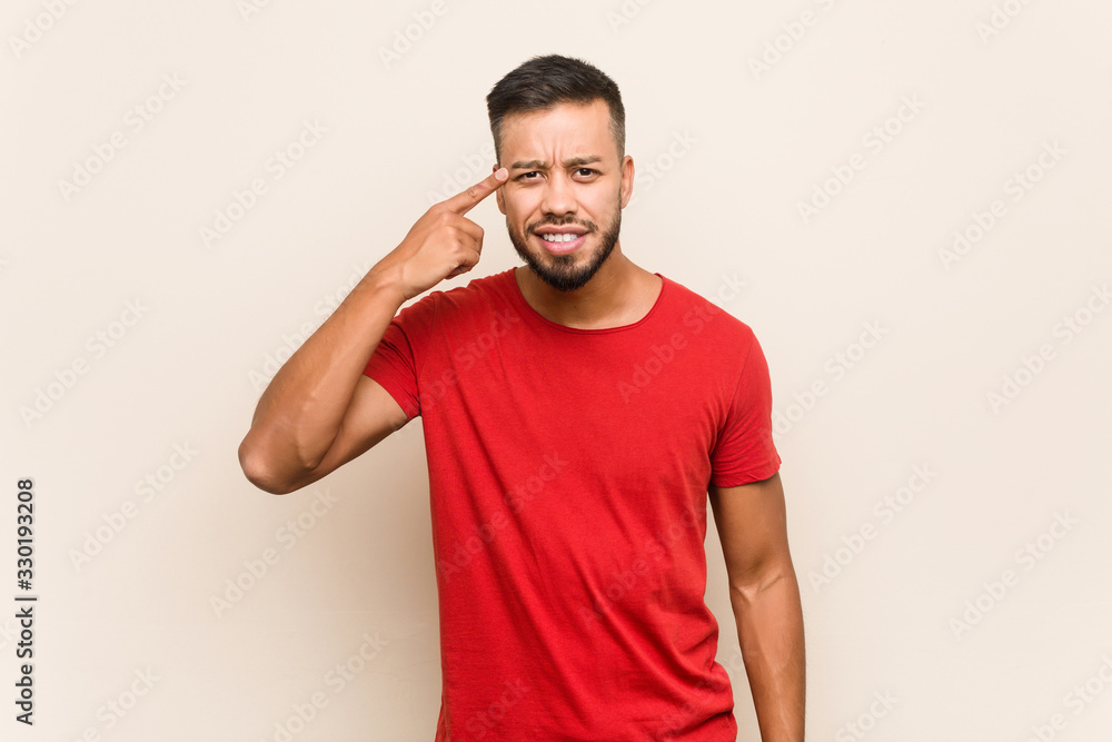 Young south-asian man showing a disappointment gesture with forefinger. Young south-asian man showing a disappointment gesture with forefinger.