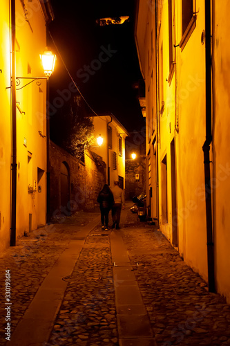 Via Palladio, con pedoni, centro storico di Monselice, Padova, Veneto, Italia, Visibile il Mastio federiciano. Fotografia notturna.