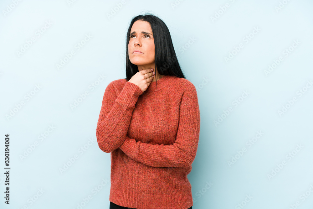 Young caucasian woman isolated on a blue background suffers pain in throat due a virus or infection. Young caucasian woman isolated on a blue background suffers pain in throat due a virus or infection.