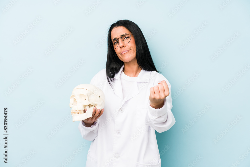 Doctor caucasian woman isolated on blue background showing fist to camera, aggressive facial expression. Doctor caucasian woman isolated on blue background showing fist to camera, aggressive facial expression.