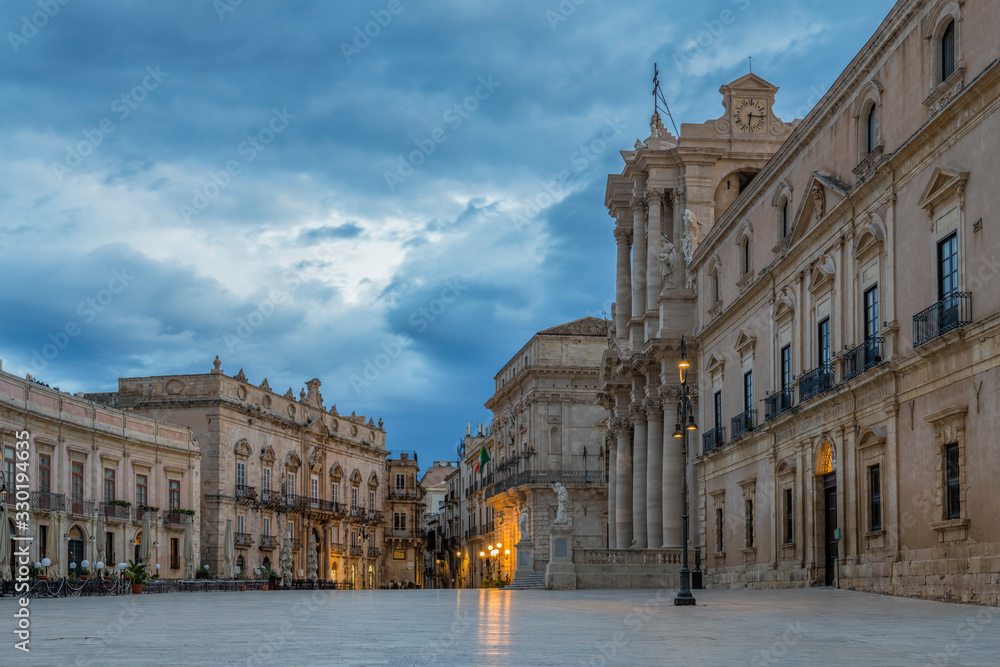 Historical empty main square in the Ortygia island (UNESCO world heritage site) at cloudy sunrise in province of Syracuse in Sicily, Italy