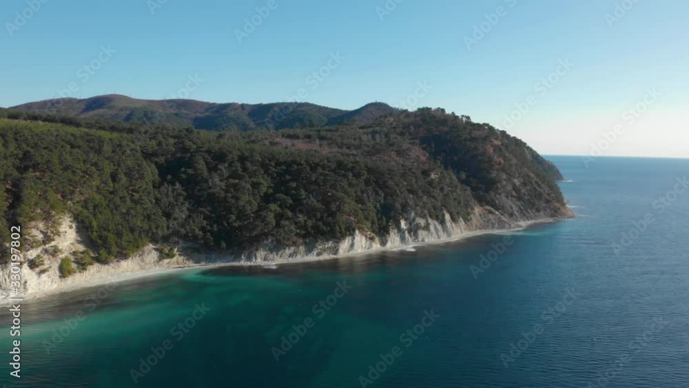 White rocks and green trees over blue sea. Aerial of coastline at sunny day White rocks and green trees over blue sea. Aerial of coastline at sunny day