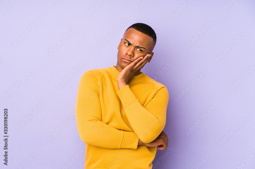 Young latin man isolated on purple background who is bored, fatigued and need a relax day. Young latin man isolated on purple background who is bored, fatigued and need a relax day.