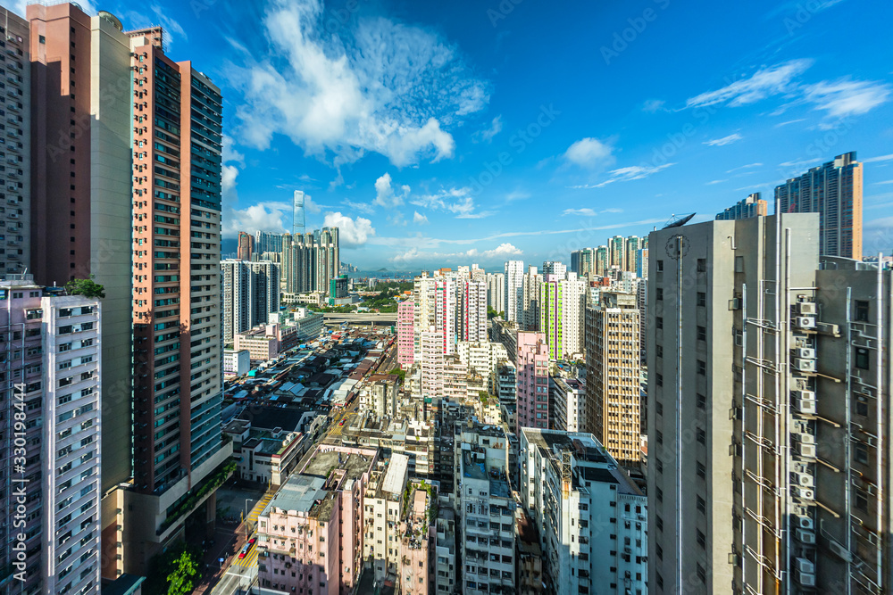 Obraz premium Cityscape of Hong Kong buildings with cloudy blue sky in morning, high angle view taken from a hotel in Yau Ma Tei (Kowloon, Hong Kong)