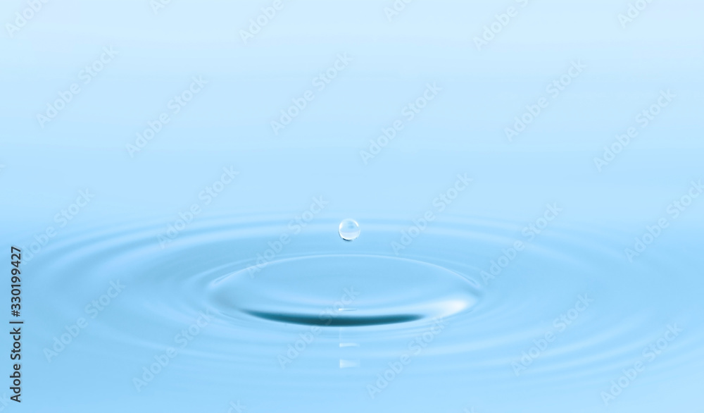 Water drop and circle ripple, light blue water, close up Water drop and circle ripple, light blue water, close up