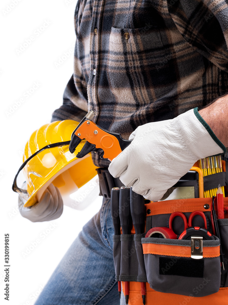 Electrician holds wire stripper plier in hand, helmet with protective goggles. Construction industry, electrical system. Isolated on a white background. Electrician holds wire stripper plier in hand, helmet with protective goggles. Construction industry, electrical system. Isolated on a white background.