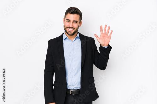 Young caucasian business man against a white background isolated smiling cheerful showing number five with fingers. photo