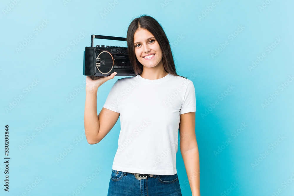 Young caucasian woman holding a guetto blaster happy, smiling and cheerful. Young caucasian woman holding a guetto blaster happy, smiling and cheerful.